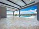 Expansive outdoor living space featuring stone tile floors and views of a sparkling pool overlooking the water at 15121 Pendio Dr, Montverde, FL 34756