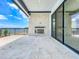 Covered patio with outdoor fireplace, lake views, and tile flooring, perfect for hosting gatherings and relaxation at 15121 Pendio Dr, Montverde, FL 34756