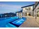 Luxury home featuring a modern pool with tiered waterfall features and meticulously landscaped backyard at 15121 Pendio Dr, Montverde, FL 34756