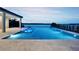 A stunning blue swimming pool overlooks the water, with an attached spa area and lots of room to relax and enjoy at 15121 Pendio Dr, Montverde, FL 34756