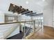 This modern staircase boasts wooden steps, metal railings, and an open design with recessed lighting and striking ceiling beams at 15121 Pendio Dr, Montverde, FL 34756
