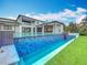 Back exterior view of house featuring an amazing in-ground swimming pool and lush backyard at 15121 Pendio Dr, Montverde, FL 34756