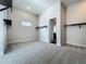 Spacious walk-in closet with multiple hanging rods and built-in shelving, plush carpeted floors and a window at 15121 Pendio Dr, Montverde, FL 34756