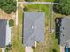 Aerial view of a home showcasing the roof, backyard, and fencing surrounded by green lawns and mature trees at 15341 Groose Point Ln, Clermont, FL 34714