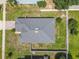 Aerial view of a home showcasing the roof, backyard, and fencing surrounded by green lawns and mature trees at 15341 Groose Point Ln, Clermont, FL 34714