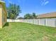 Spacious backyard enclosed by a white fence offering a private outdoor space with lush green grass at 15341 Groose Point Ln, Clermont, FL 34714