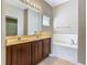 Bathroom features a dual sink vanity and a separate soaking tub at 15341 Groose Point Ln, Clermont, FL 34714