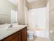 Bathroom featuring a vanity with dark wood cabinets and white tub shower combo at 15341 Groose Point Ln, Clermont, FL 34714