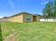 Back exterior view of the house showing siding, windows, door, and a fully fenced yard at 15341 Groose Point Ln, Clermont, FL 34714