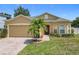 Charming single-story home featuring a well-manicured lawn, brick driveway, and a beautiful palm tree in the front yard at 15341 Groose Point Ln, Clermont, FL 34714