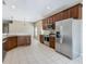 Spacious kitchen with stainless steel refrigerator, range, and dark wood cabinetry at 15341 Groose Point Ln, Clermont, FL 34714