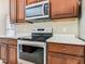 Kitchen detail featuring stainless steel appliances, white countertops, and wood cabinets at 15341 Groose Point Ln, Clermont, FL 34714