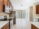 Kitchen with stainless steel appliances and a view into the bright dining area at 15341 Groose Point Ln, Clermont, FL 34714