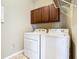 Convenient laundry room includes a washer, dryer, and overhead storage at 15341 Groose Point Ln, Clermont, FL 34714