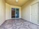 Covered patio features decorative tile flooring and access to the backyard through sliding glass doors at 15341 Groose Point Ln, Clermont, FL 34714