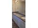 Bathroom showcasing a double sink vanity with granite countertop, modern lighting, and a large mirror at 1556 Aspen Ave, Davenport, FL 33837