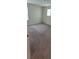 An empty bedroom with neutral carpeting, baseboards, and minimal natural light at 1556 Aspen Ave, Davenport, FL 33837