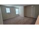 An empty bedroom with neutral carpeting, baseboards, natural light, and a door at 1556 Aspen Ave, Davenport, FL 33837