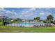 Community pool and splash pad with seating, surrounded by manicured landscaping and beautiful homes at 1556 Aspen Ave, Davenport, FL 33837