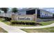 The Forest Lake community sign is framed by colorful flowers, landscaping, and sidewalks at 1556 Aspen Ave, Davenport, FL 33837