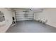 Spacious two-car garage featuring an epoxy floor, overhead door, and ample room for vehicles at 1556 Aspen Ave, Davenport, FL 33837