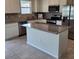 Kitchen island featuring granite countertops, white cabinets and stainless steel appliances at 1556 Aspen Ave, Davenport, FL 33837