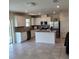 Open kitchen features white cabinetry, stainless appliances, and center island with stone countertops at 1556 Aspen Ave, Davenport, FL 33837