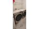 Modern laundry room featuring a front-load washer and dryer set with a shelf above at 1556 Aspen Ave, Davenport, FL 33837