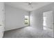 Inviting bedroom with neutral carpet, ceiling fan and a view to the outside at 16614 Lazy Breeze Loop, Clermont, FL 34714
