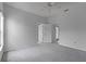 This bedroom features neutral carpet, a ceiling fan and multiple entry doors at 16614 Lazy Breeze Loop, Clermont, FL 34714