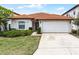 Charming single-story home showcasing a red tile roof, well-maintained lawn, and an attached two-car garage at 16614 Lazy Breeze Loop, Clermont, FL 34714
