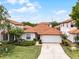 Aerial shot showcasing a single-story home with red tile roof, and mature trees at 16614 Lazy Breeze Loop, Clermont, FL 34714