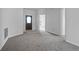 Spacious living room featuring neutral carpet and a dark wooden front door at 16614 Lazy Breeze Loop, Clermont, FL 34714