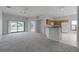 Open concept living room with kitchen featuring neutral carpet and sliding glass doors to outdoor space at 16614 Lazy Breeze Loop, Clermont, FL 34714