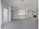 Bright and open living room featuring neutral carpet, ceiling fan, and views to the front door at 16614 Lazy Breeze Loop, Clermont, FL 34714