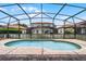 Inviting in-ground pool featuring a screened enclosure, set among neighboring homes at 16614 Lazy Breeze Loop, Clermont, FL 34714