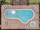 Aerial view of a pool with lounge chairs on brick surround and jacuzzi, perfect for relaxation and recreation at 16614 Lazy Breeze Loop, Clermont, FL 34714
