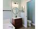 Bathroom with a modern sink vanity, a stylish round mirror, and vinyl floors at 2312 Twickingham Ct, Clermont, FL 34711