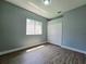 Bedroom with wood-look flooring, window, closet, and gray walls at 2312 Twickingham Ct, Clermont, FL 34711