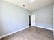 Bedroom with wood-look flooring, gray walls and a door to another room at 2312 Twickingham Ct, Clermont, FL 34711