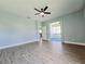 A bedroom with wood-look flooring, a ceiling fan, and an exterior door at 2312 Twickingham Ct, Clermont, FL 34711