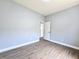 Bedroom with wood-look flooring, and a door to another room with gray walls at 2312 Twickingham Ct, Clermont, FL 34711