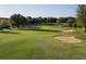 Lush green golf course featuring mature trees, sand traps, and rolling hills, creating a challenging and scenic experience at 2312 Twickingham Ct, Clermont, FL 34711