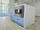 A Kitchen island featuring a built-in microwave and quartz countertops at 2312 Twickingham Ct, Clermont, FL 34711