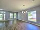 An open-concept living area with gleaming hardwood floors, and modern chandelier at 2312 Twickingham Ct, Clermont, FL 34711