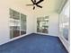 Enclosed lanai featuring sliding glass doors and dark blue carpet at 2312 Twickingham Ct, Clermont, FL 34711