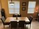 Traditional dining room area featuring a wood table, upholstered chairs, and two bright windows at 2495 Palm Tree Dr, Kissimmee, FL 34759