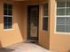 Front door is centered between two windows and offers a brick paved entrance and is decorated with a patterned front door at 2495 Palm Tree Dr, Kissimmee, FL 34759