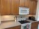 A well-lit kitchen showcases a range, microwave and countertops with wood cabinets at 2495 Palm Tree Dr, Kissimmee, FL 34759