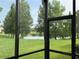 View of a serene pond and lush green lawn from screened lanai provides peaceful outdoor living at 2495 Palm Tree Dr, Kissimmee, FL 34759